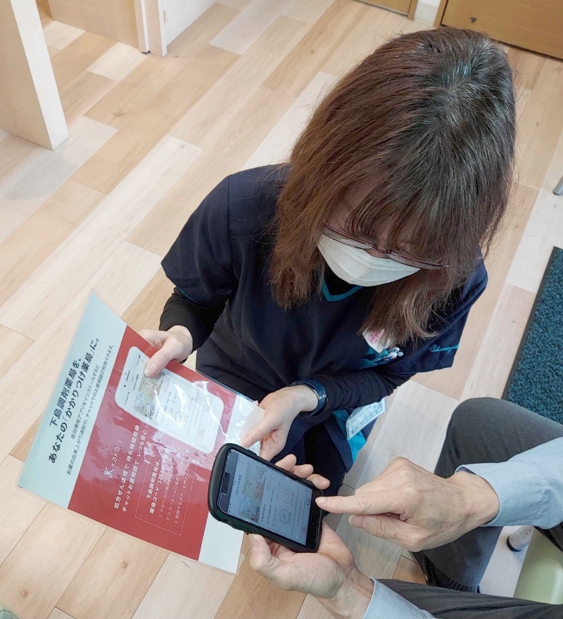 チラシを用いて患者様にご案内する石井様